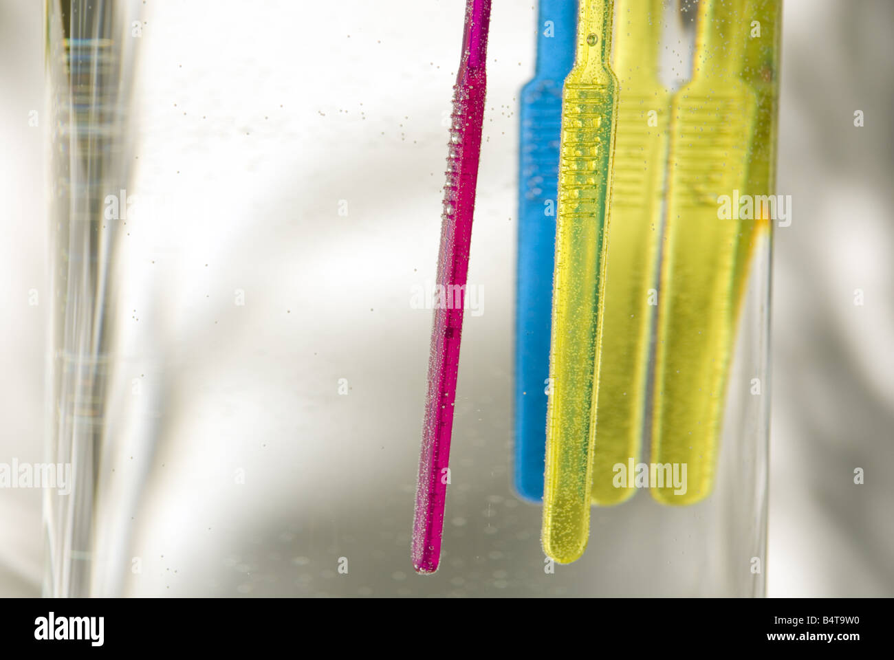 Nahaufnahme von untergetaucht und schwimmenden bunten Zahnbürsten in Glasvase Stockfoto