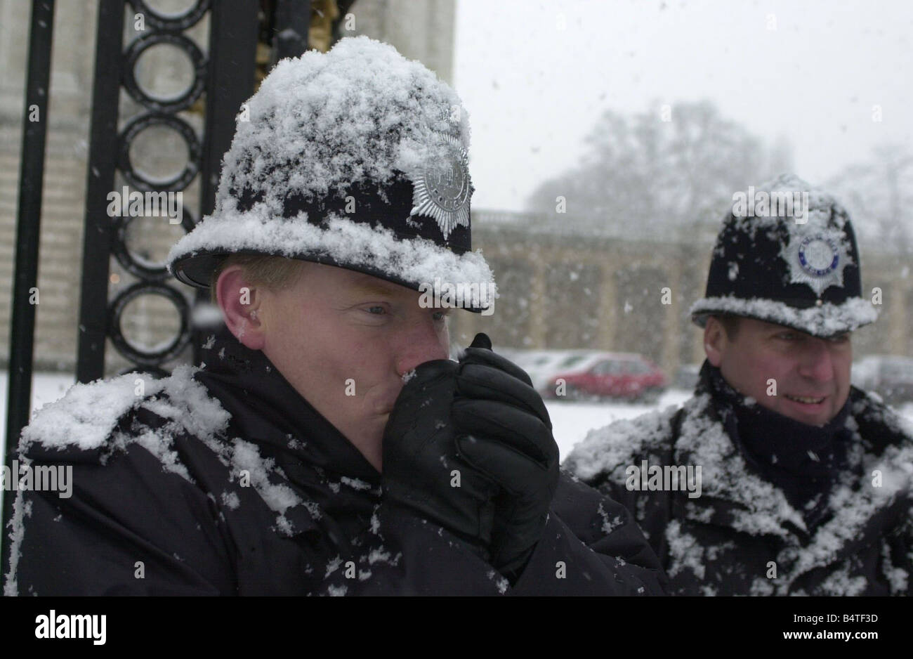 Schnee fällt in London nach langer Zeit Januar 2003 Polizisten versuchen, in den Schnee draußen Buckingham Palace Mirrorpix warm zu halten Stockfoto