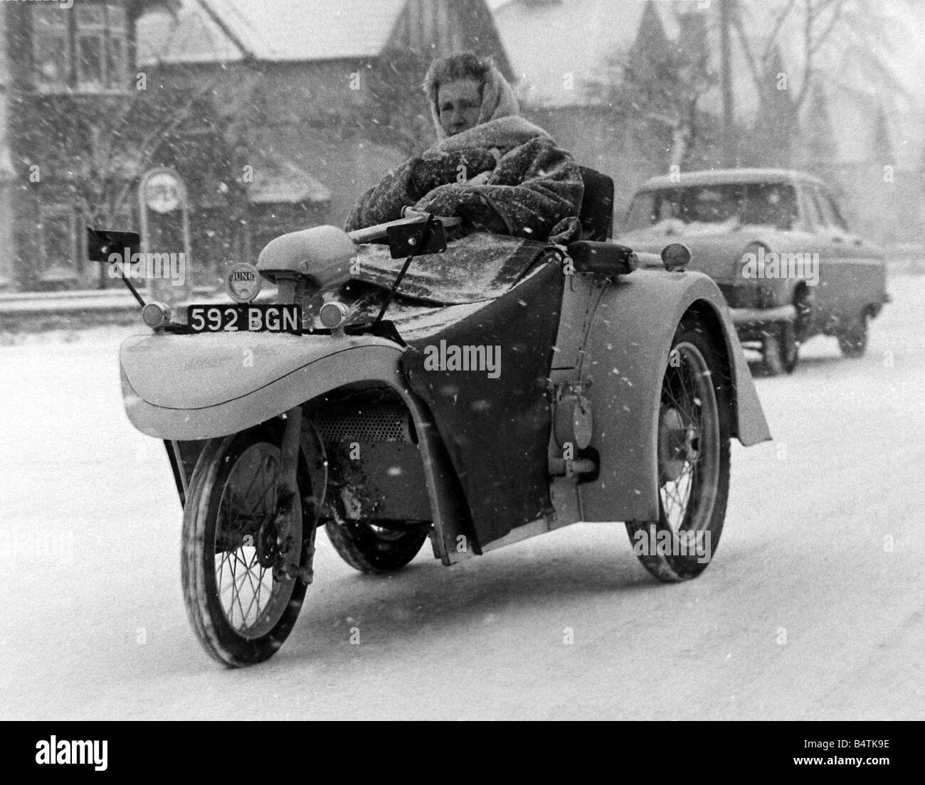 Wetter Schnee Kälte Fahrzeuge Biggin Hill in Kent wurde der Schnee so schlecht, dass Verkehr zum stehen noch eine Frau in ihrem Fahrzeug in der Kälte kam sitzt, eingehüllt in einen Schal und dichtes Fell Stockfoto