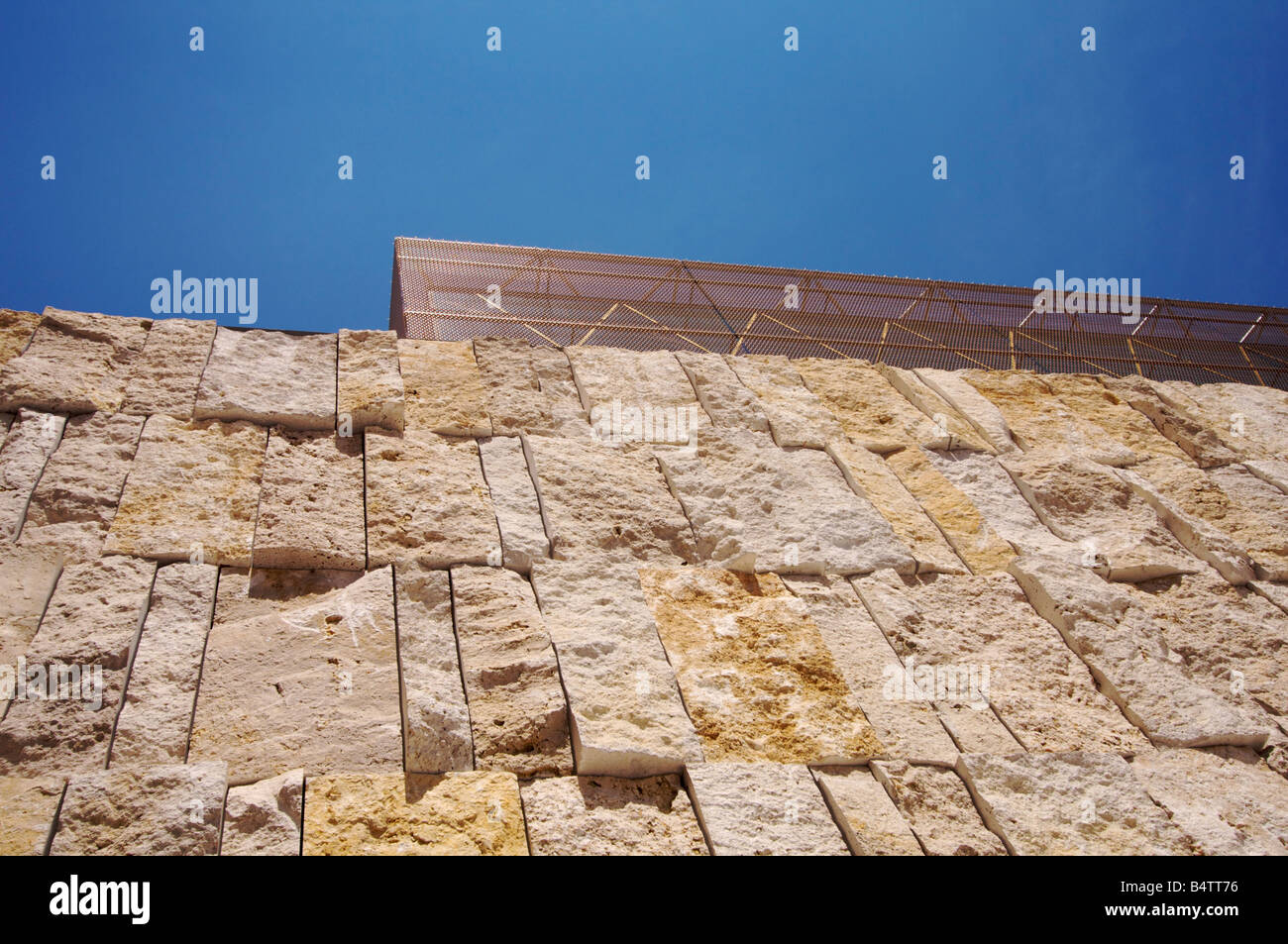 Teile der Basis Steinmauer und der oberen Glaskubus der Hauptsynagoge Ohel Jakob in München unter blauem Himmel. Stockfoto