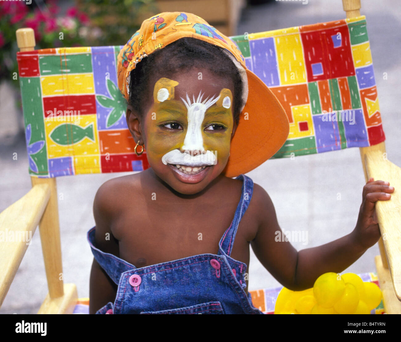 Porträt eines jungen schwarzen Mädchens, dessen Gesicht in Form einer Katze  von Kinder Gesicht Maler in einem Park in old Montreal, Kanada gemalt wurde  Stockfotografie - Alamy