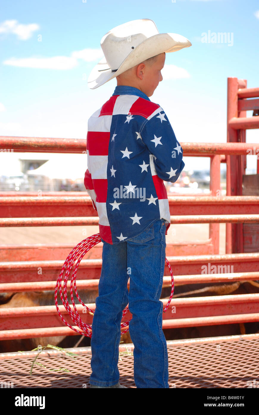 Eine patriotische kleine Cowboy hält seine Hand über seinem Herzen spielen für die amerikanische Nationalhymne Stockfoto