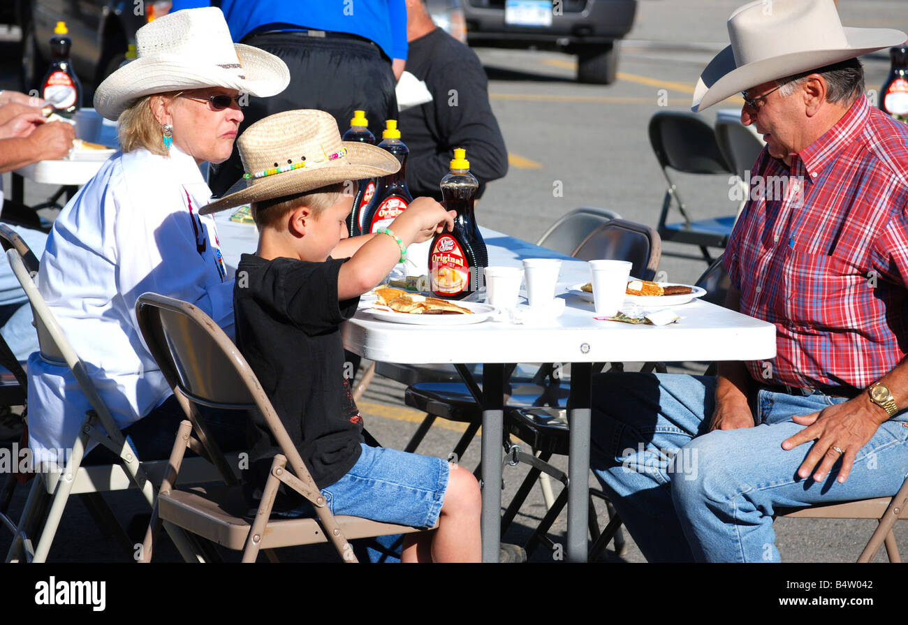 Ein Cowboy und seine Frau essen Pfannkuchen mit ihrem Enkel in einem rotary Club-Pancake-Frühstück Stockfoto