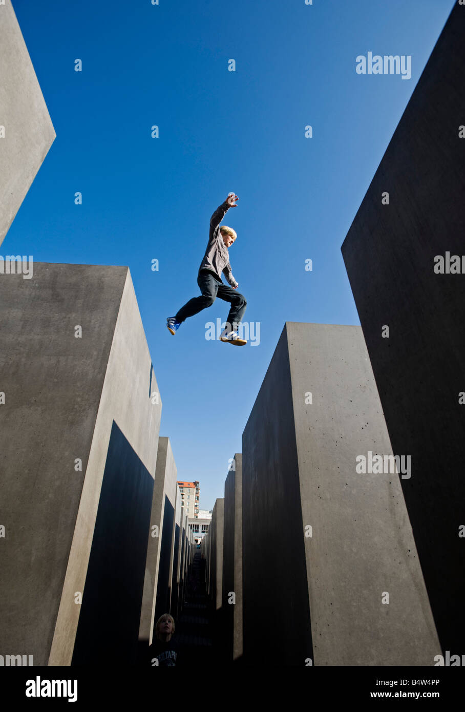 Junge, springen zwischen Betonklötzen am Denkmal für die ermordeten Juden Europas im zentralen Berlin Deutschland 2008 Stockfoto