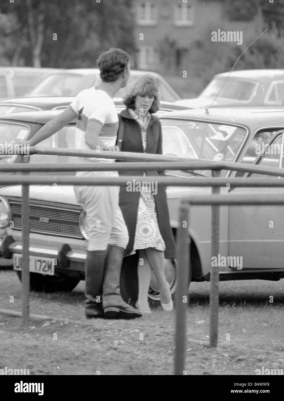 Prinz Charles lehnt sich zurück auf Geländer, als er während einer Pause in einem Polo-Spiel im Windsor Great Park Royal Prince Of Wales Sport Freundin June1975 der 1970er Jahre Mirrorpix mit Camilla Parker Bowles plaudert Stockfoto