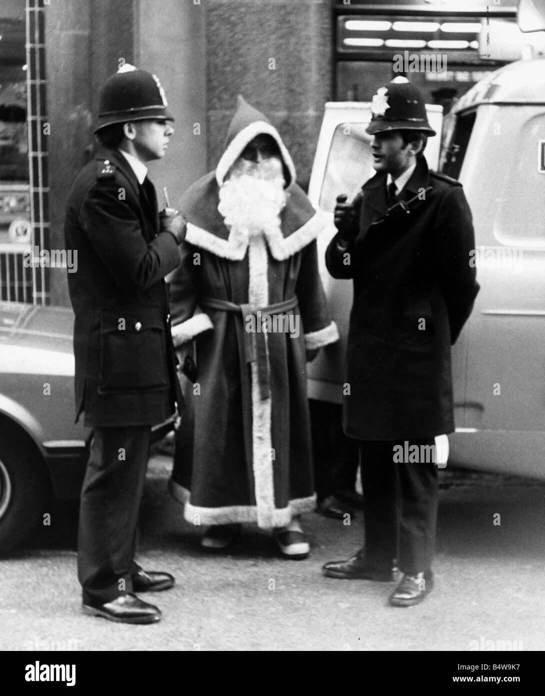 Polizisten zu sprechen, an den Weihnachtsmann outise Kaufhaus Harrods in London nach geklaut werden, denn Obstruktion Santa bot mit Passanten darstellen, während ein Kollege nahm Dezember 1982 Bilder Mirrorpix Stockfoto