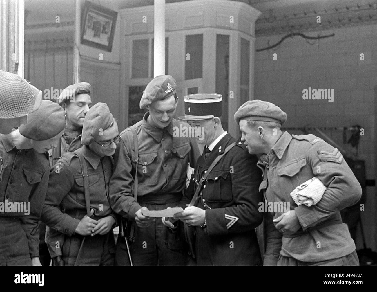 Britische Truppen im Gespräch mit einem lokalen Gendarmen in einer Stadt der Normandie in Nordfrankreich kurz nach dem D-Day Landungen begonnen die alliierte Invasion des Kontinents im Weltkrieg 2. Juli 1944 Stockfoto