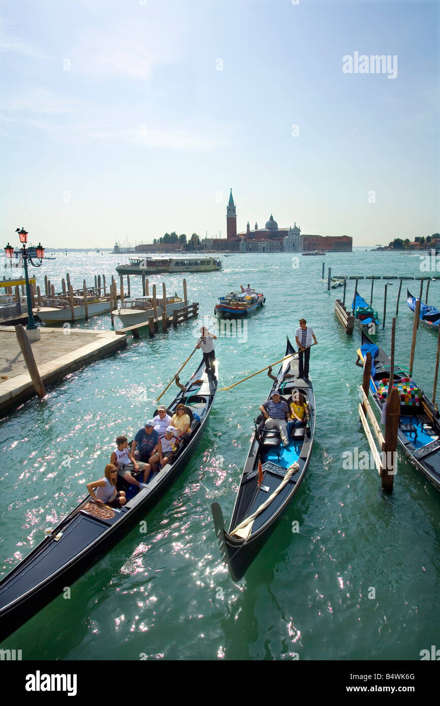 Venedig-Leute Reiten in Gondeln und die Basilica di San Giorgia in der Ferne Stockfoto