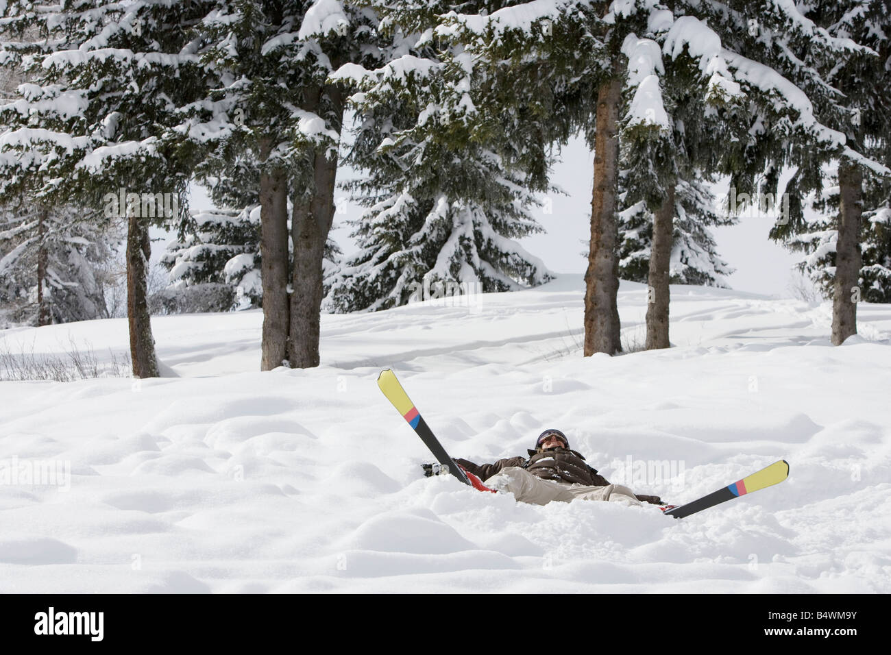 Frau im Schnee mit Skiern liegen Stockfoto