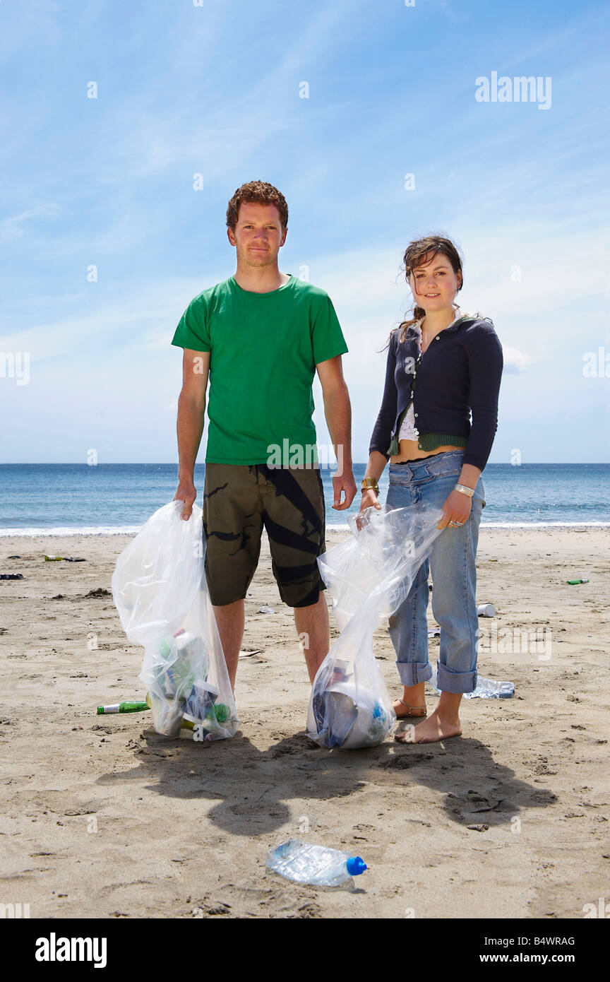 Junges Paar sammeln Müll am Strand Stockfoto