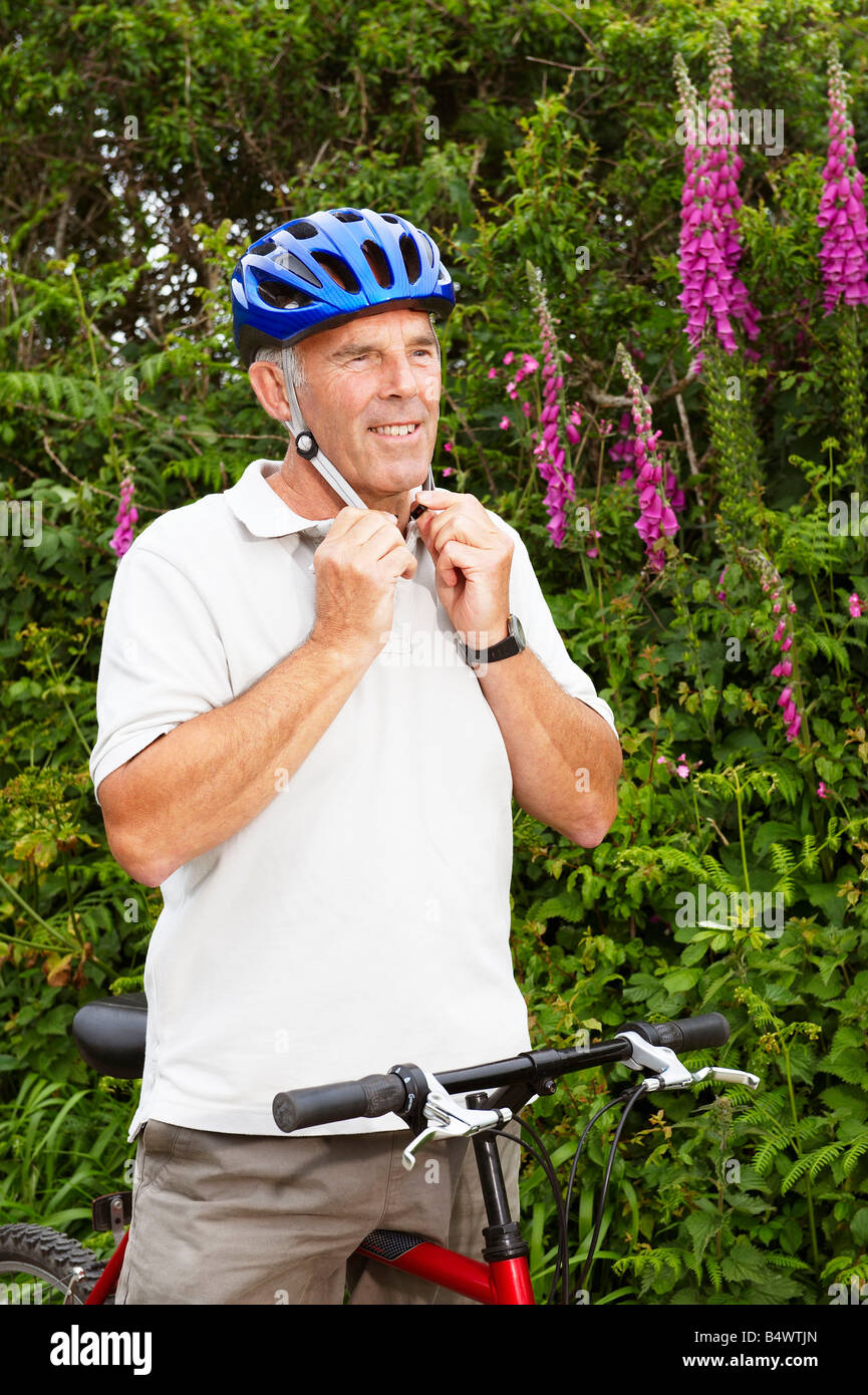 Senior woman Befestigung Fahrradhelm Stockfoto