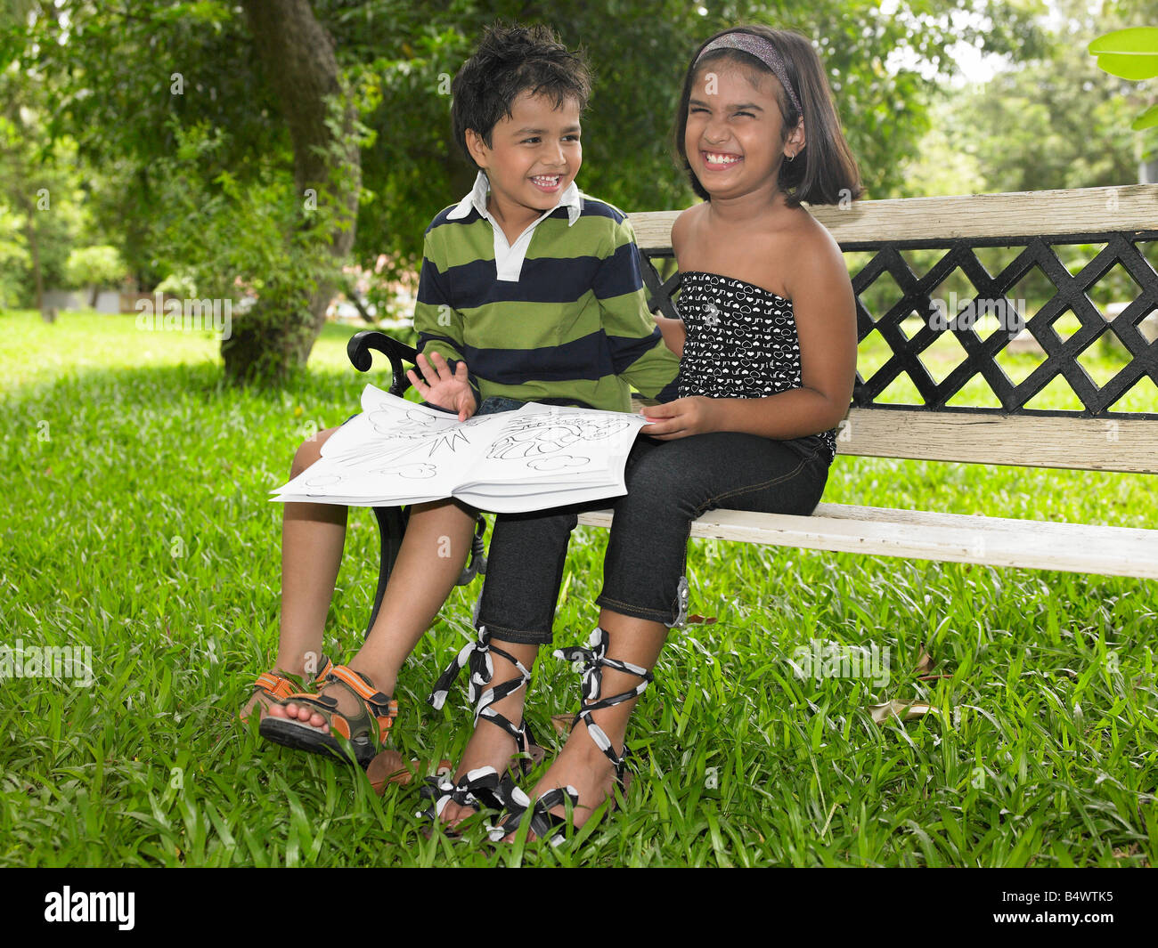 Asiatische Kinder lesen ein Buch in einem park Stockfoto