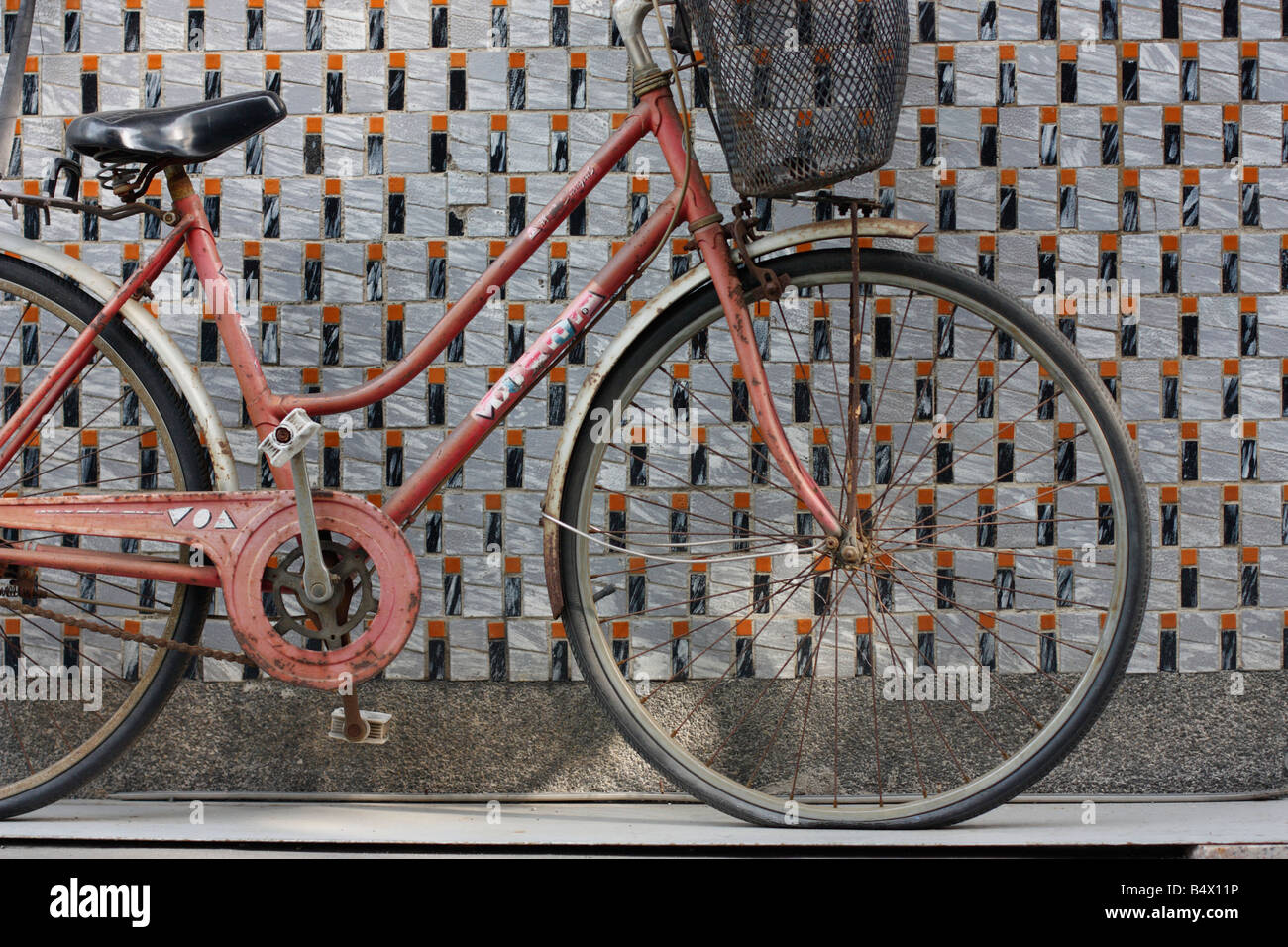 Alte Frauen Fahrrad eine geflieste Wand gelehnt. Stockfoto