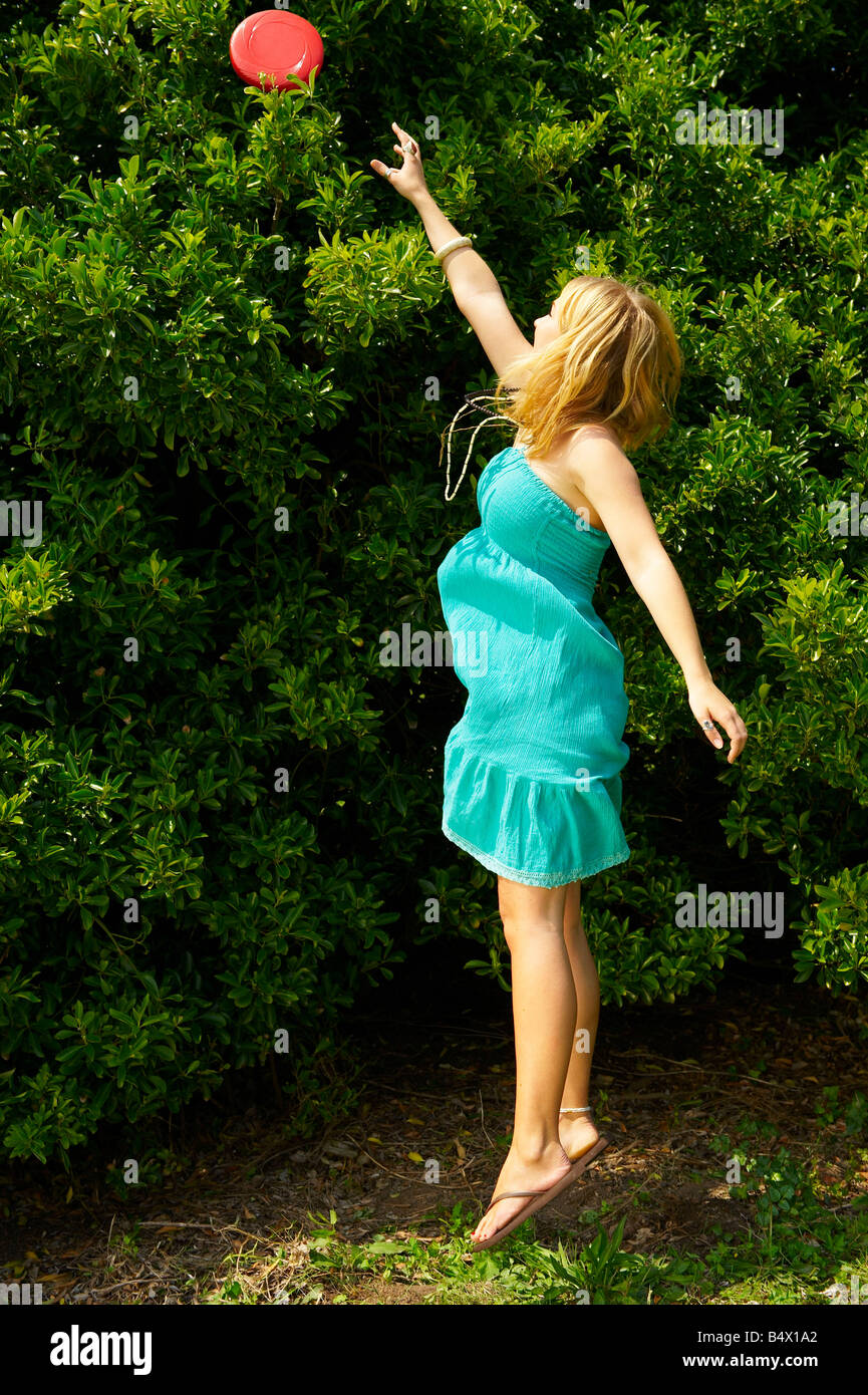 Frau, springen, um eine Frisbee zu erreichen Stockfoto
