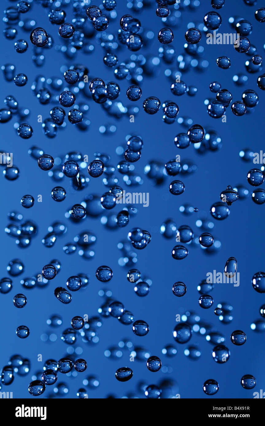 Wassertröpfchen in der Luft vor einem blauen Hintergrund erfasst Stockfoto