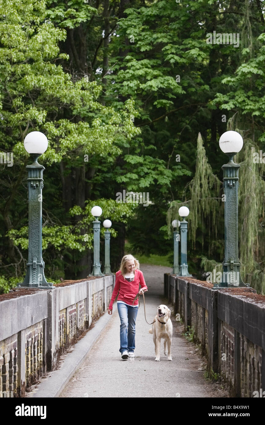 Mädchen zu Fuß Hund über Brücke Stockfoto