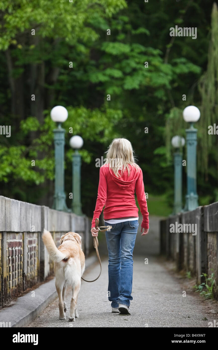 Mädchen zu Fuß Hund über Brücke Stockfoto