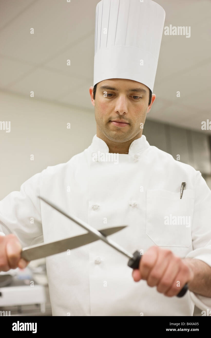 Kochmesser schärfen in Küche Stockfoto