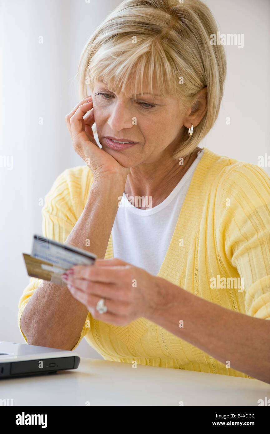 Frau Kreditkarten mit Sorge betrachten Stockfoto