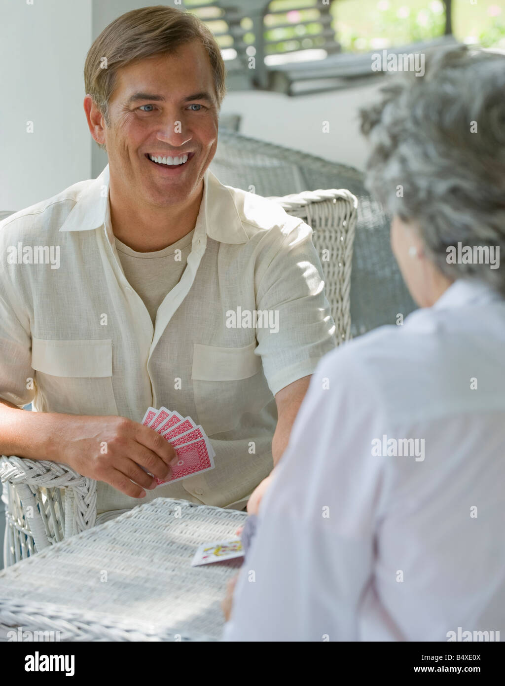 Mutter und erwachsener Sohn Spielkarte Spiel auf Veranda Stockfoto