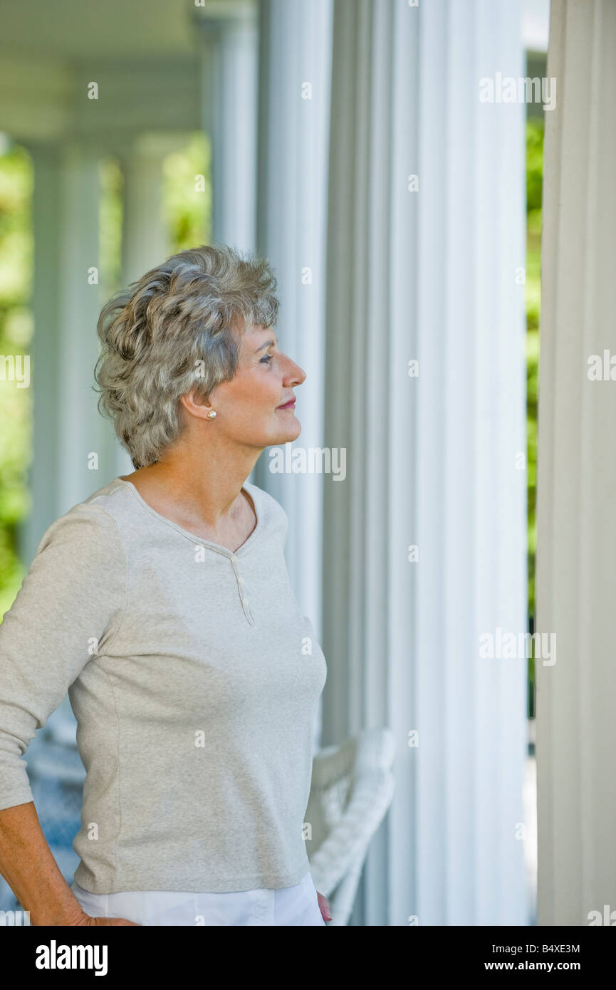 Ältere Frau, die auf Veranda Stockfoto