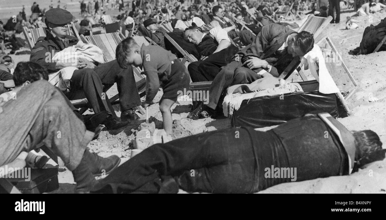 Faule Sommertage.; Die Mittagssonne sendet Urlauber auf Margate Beach zu schlafen. Jedoch weiterhin ein Jugendlicher seine Sandburgen bauen, während jeder sonst 40 Winks hat.; August 1946 Stockfoto