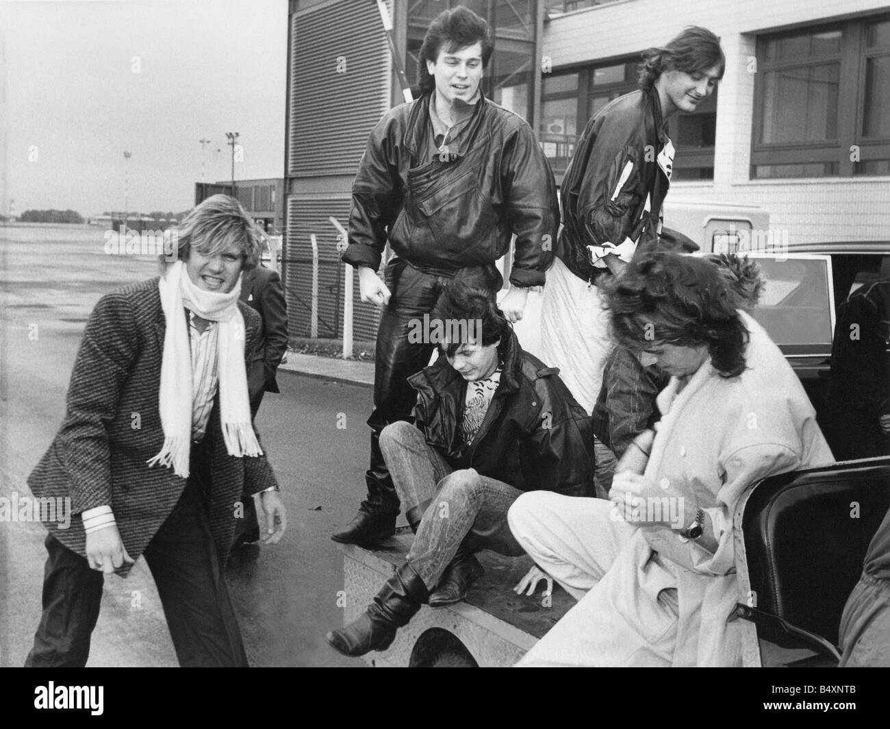 Duran Duran hitch eine Fahrt auf einem Gepäck-Wagen bei ihrer Ankunft am Newcasle Flughafen L R unteren Bild Simon le Bon Andy Tayor John Taylor Nick Rhodes versteckt hinter John Roger Taylor Lederhose 29 10 84 Stockfoto