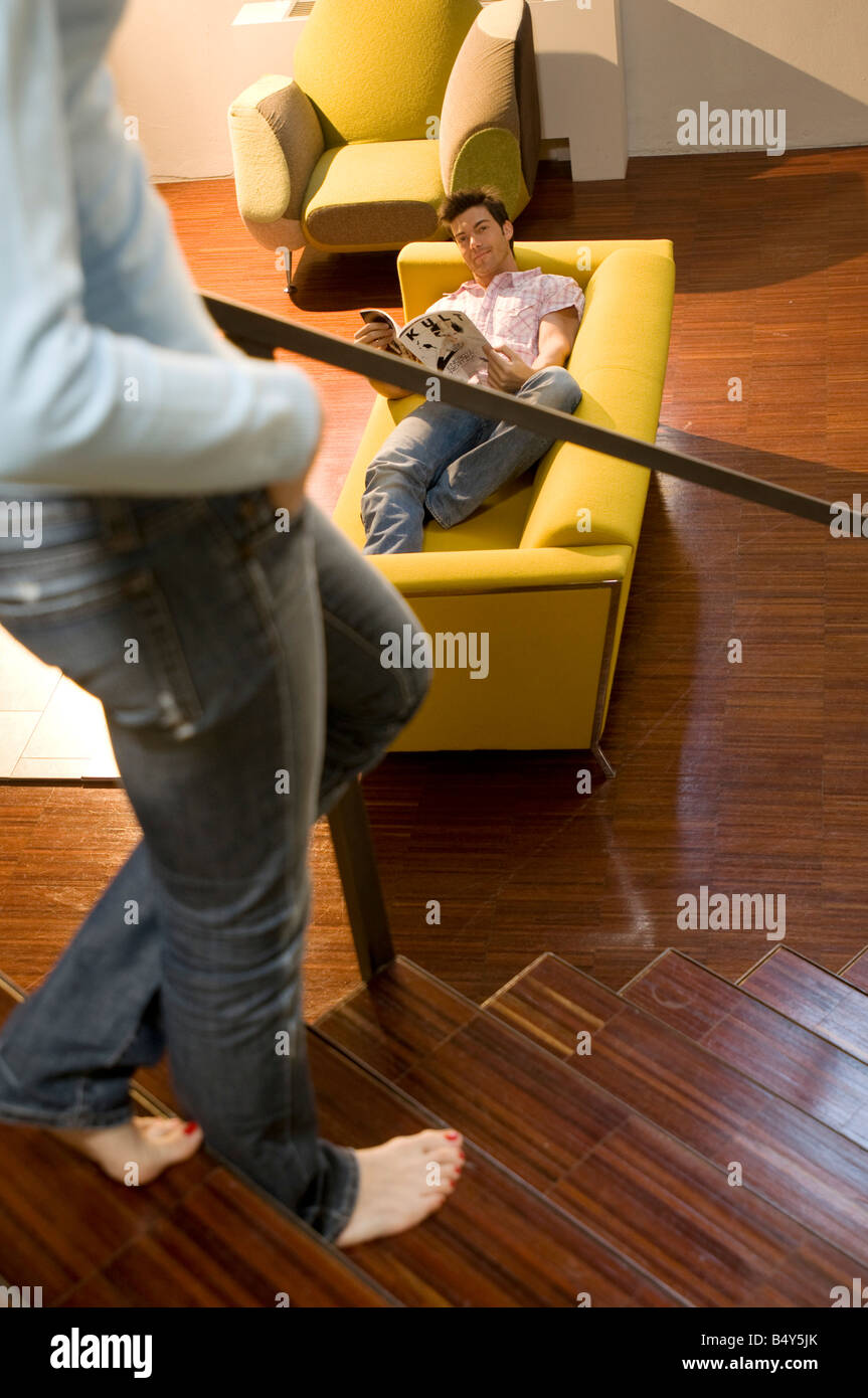 Frau auf der Treppe und Mann auf Diwan Stockfoto