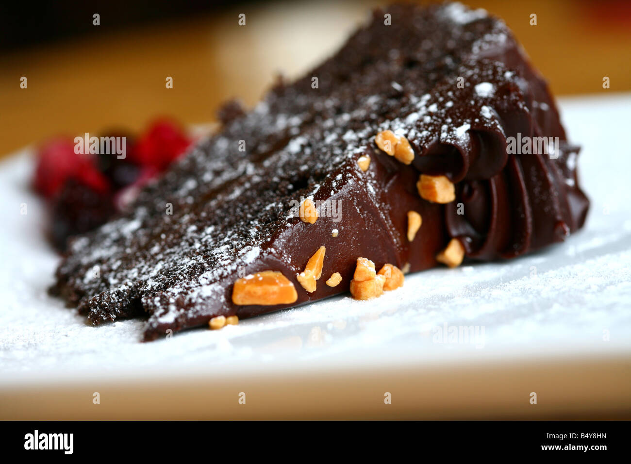 Reiche Schokoladenkuchen mit Einsprengsel von Nüssen und einer Prise Puderzucker Stockfoto