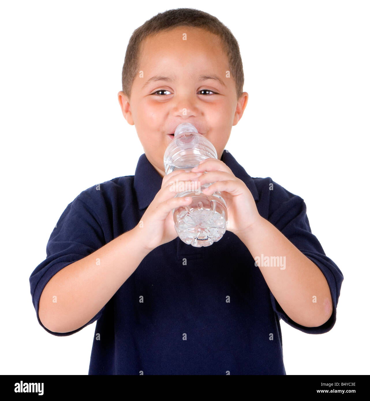 Glückliche junge Latino trinken aus Wasserflasche auf weißem Hintergrund Stockfoto