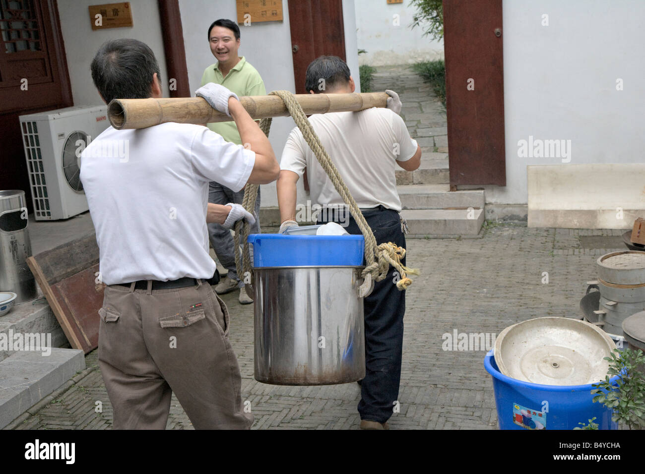 Chinesische Art, schmutziges Geschirr tragen Bambusstange benutzen und teilen die Last, Nanjing / China Stockfoto