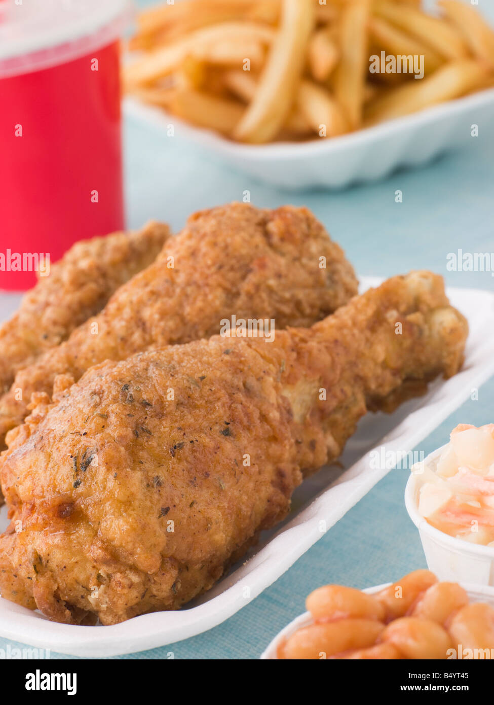 Southern Fried Chicken mit Pommes frites, gebackene Bohnen, Krautsalat und ein alkoholfreies Getränk Stockfoto