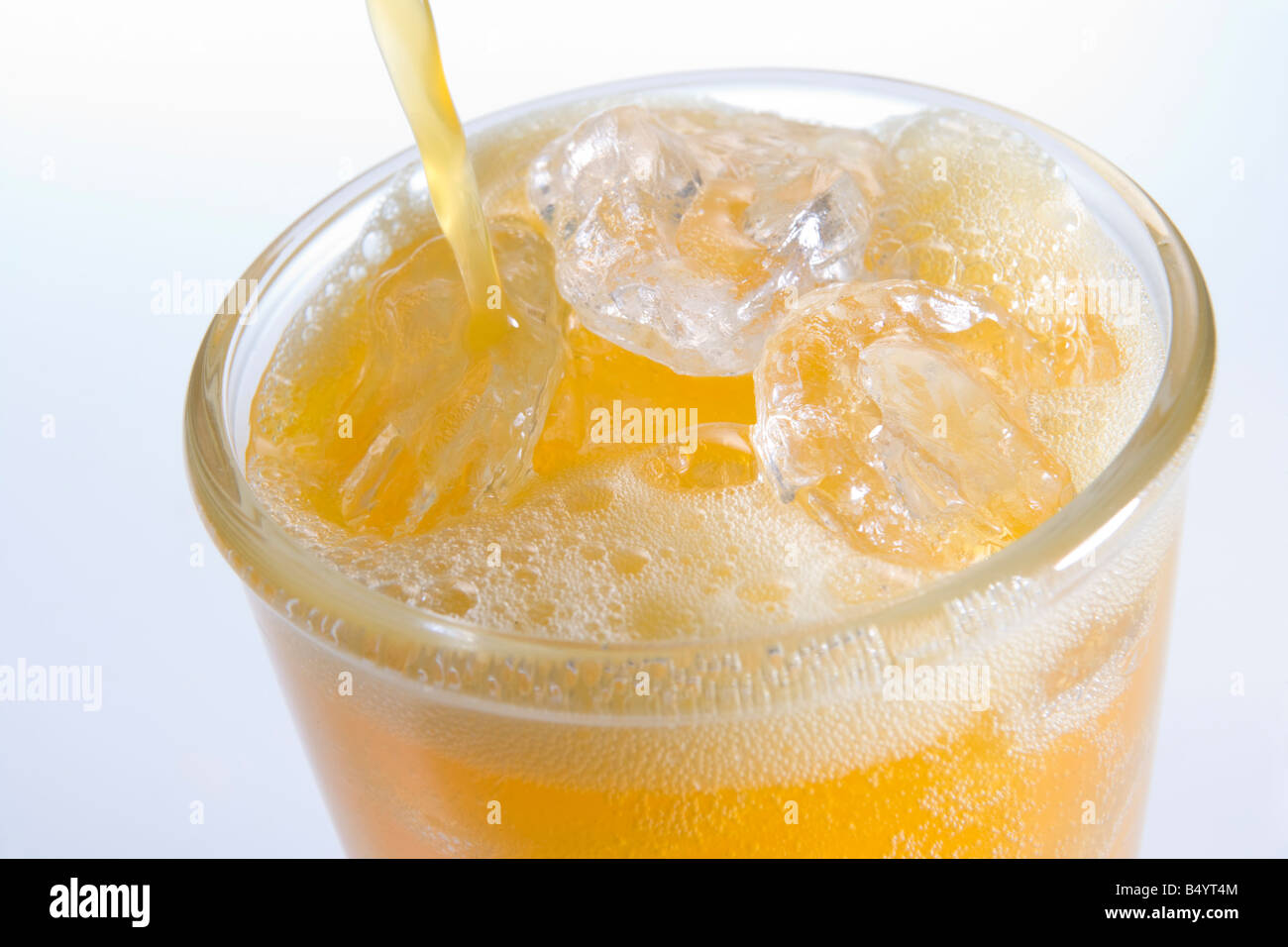 Orangenlimonade in einem Glas aus Eis gießen Stockfoto