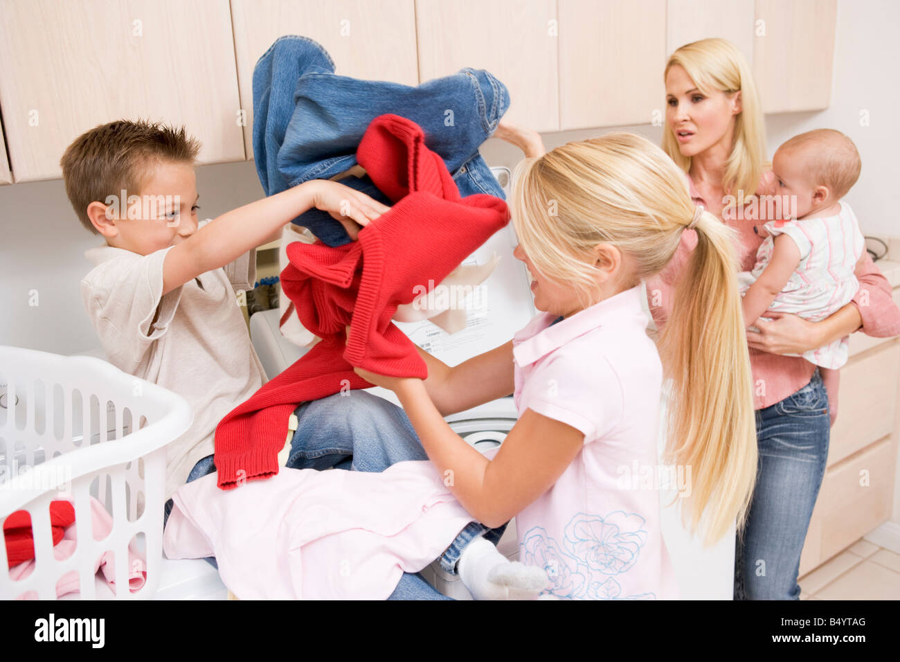 Geschwister kämpfen beim Wäschewaschen Stockfoto