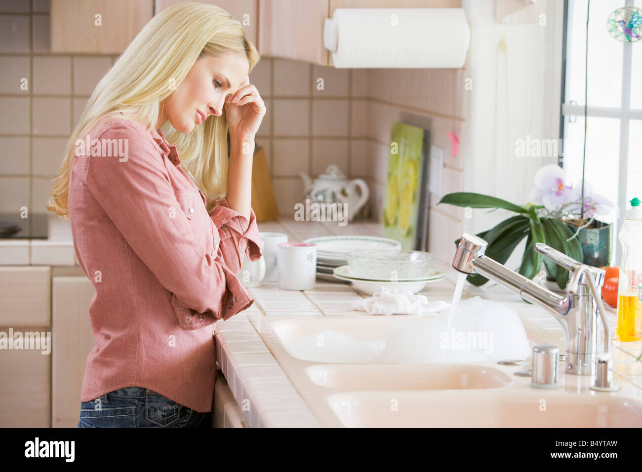 Frau am Küchentisch frustriert Stockfoto