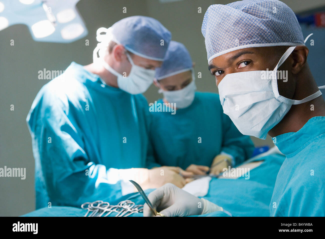 Vier Chirurgen immer bereit, auf einen Patienten Stockfoto
