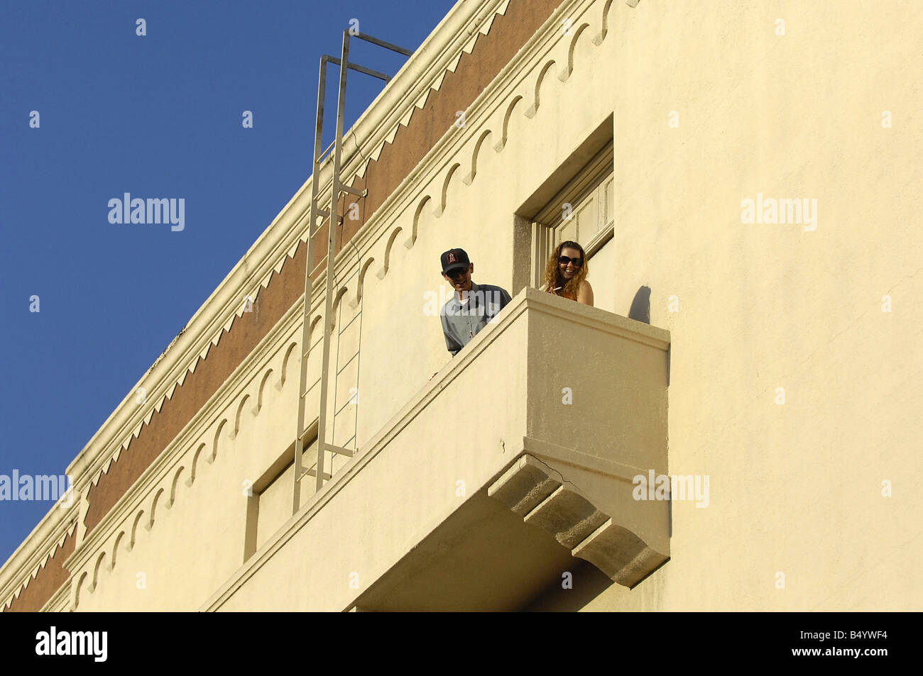 Ein Mann und eine Frau treten Sie auf den Balkon, um eine Zigarette zu rauchen und genießen Sie den Blick Stockfoto