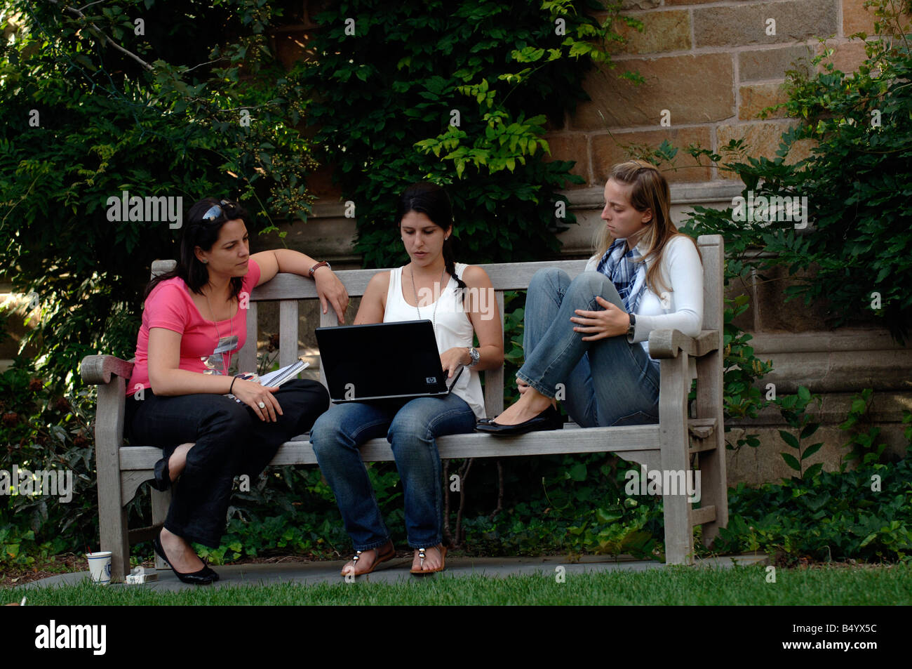 Yale Universität europäischen Sommer Schülerinnen und Schüler mit Laptop auf Bank in Branford Hochschule Hof Stockfoto
