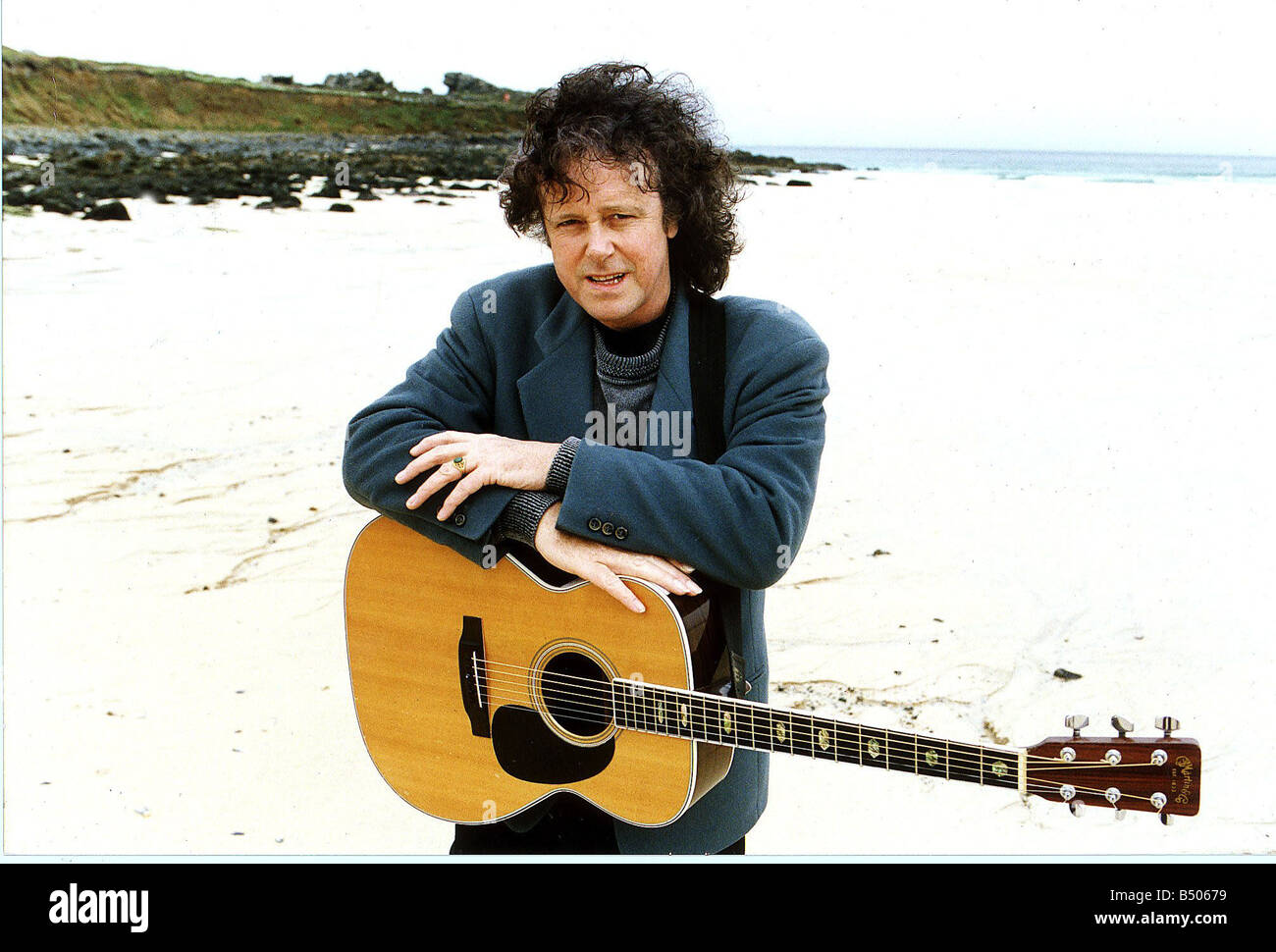 Donovan-Pop-Star der 60er Jahre im Bild an einem Strand mit seiner Gitarre um den Hals hängen Stockfoto