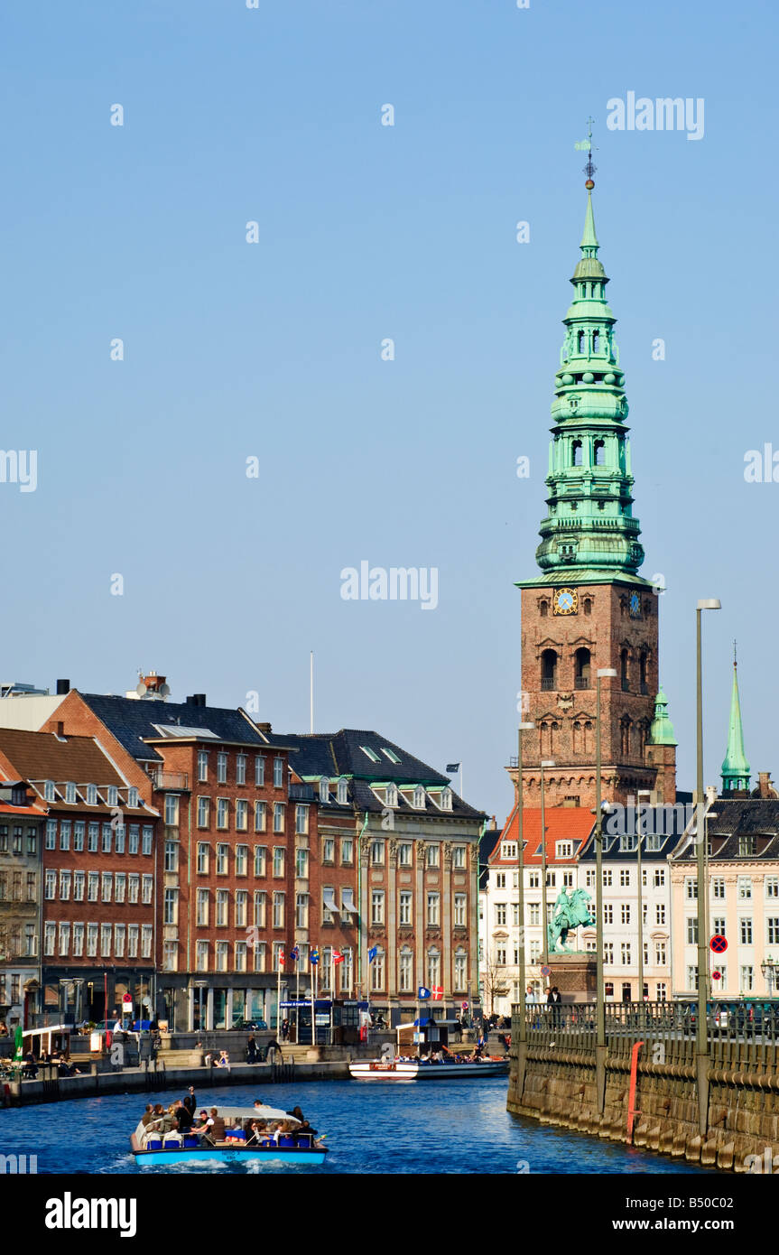 Ausflugsschiff auf einem Kanal in Kopenhagen København mit Turm von Sankt Nicolai Kirke hinter Stockfoto
