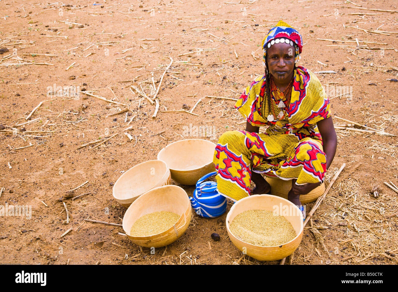 Eine Fulbe-Frau trennt Spreu in einem Dorf im südwestlichen Niger Hirse Samen. Stockfoto