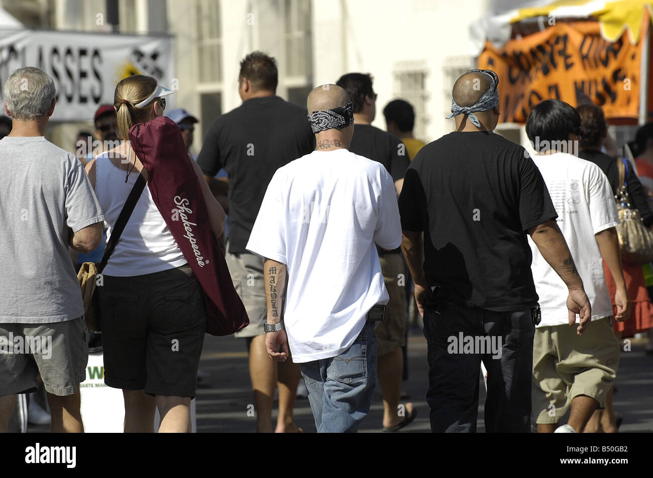 Verdacht auf Straßengang Mitglieder Spaziergang durch einen überfüllten Strassenfest Stockfoto