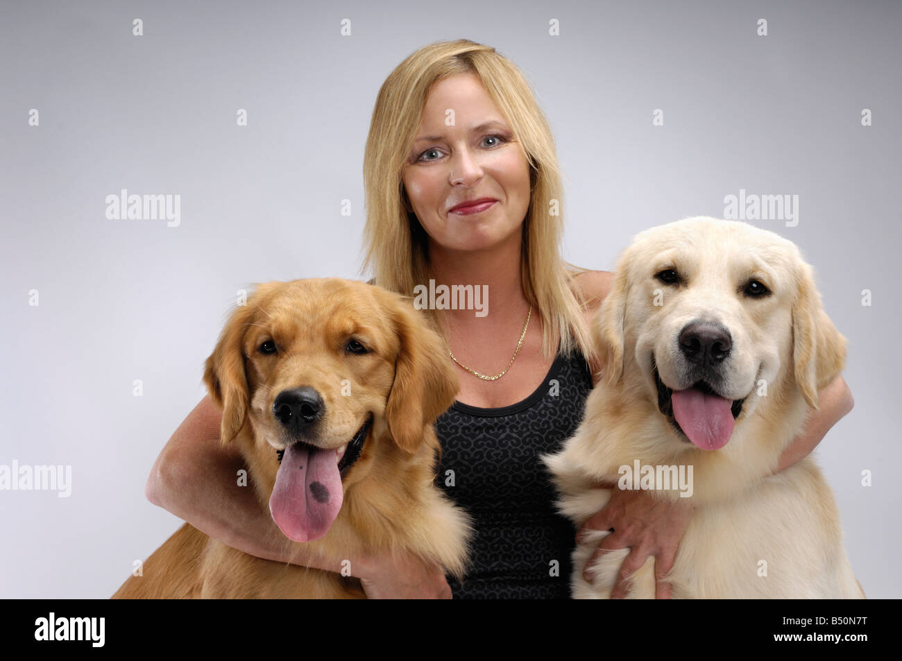 Führerschein verfügbar unter MaximImages.com - Frau mit zwei Golden Retrievers Haustieren Hundebetreuung Stockfoto