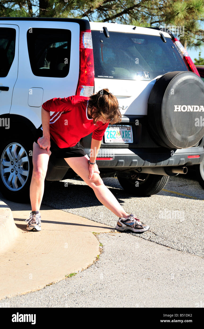 Frau, die Shorts trägt, streckt vor dem laufen aus. USA. Stockfoto