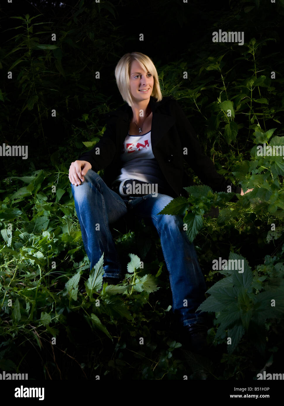 junge Frau in Brennnessel-Wald Stockfoto