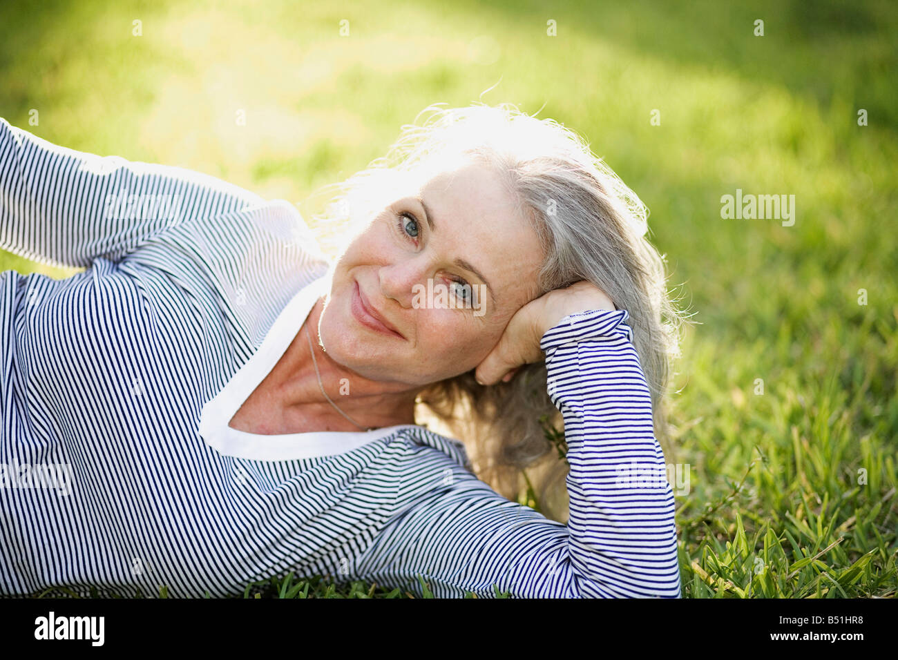Porträt der Frau im Gras liegen Stockfoto