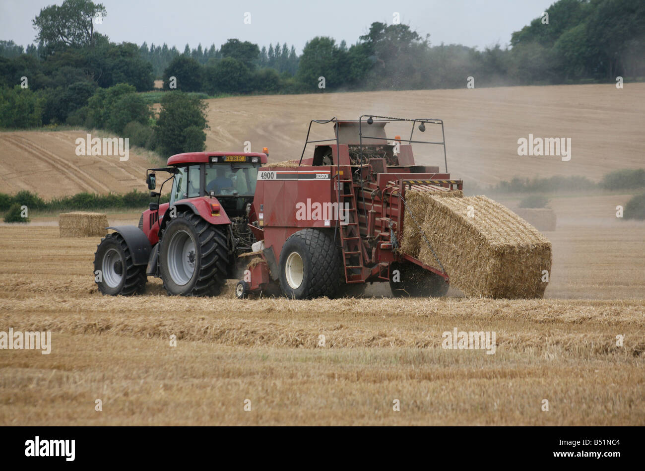 Traktor machen Heu Bails nach der Sommer-Ernte in Clare Suffolk East Anglia UK Stockfoto