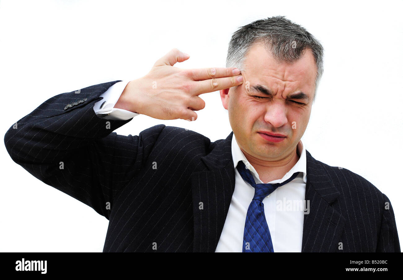 Ein Geschäftsmann zeigt seine Finger auf den Kopf, gestikulieren, die er vor sich geht, sich zu erschießen. Bild von Patrick Stahl Patricksteel Stockfoto