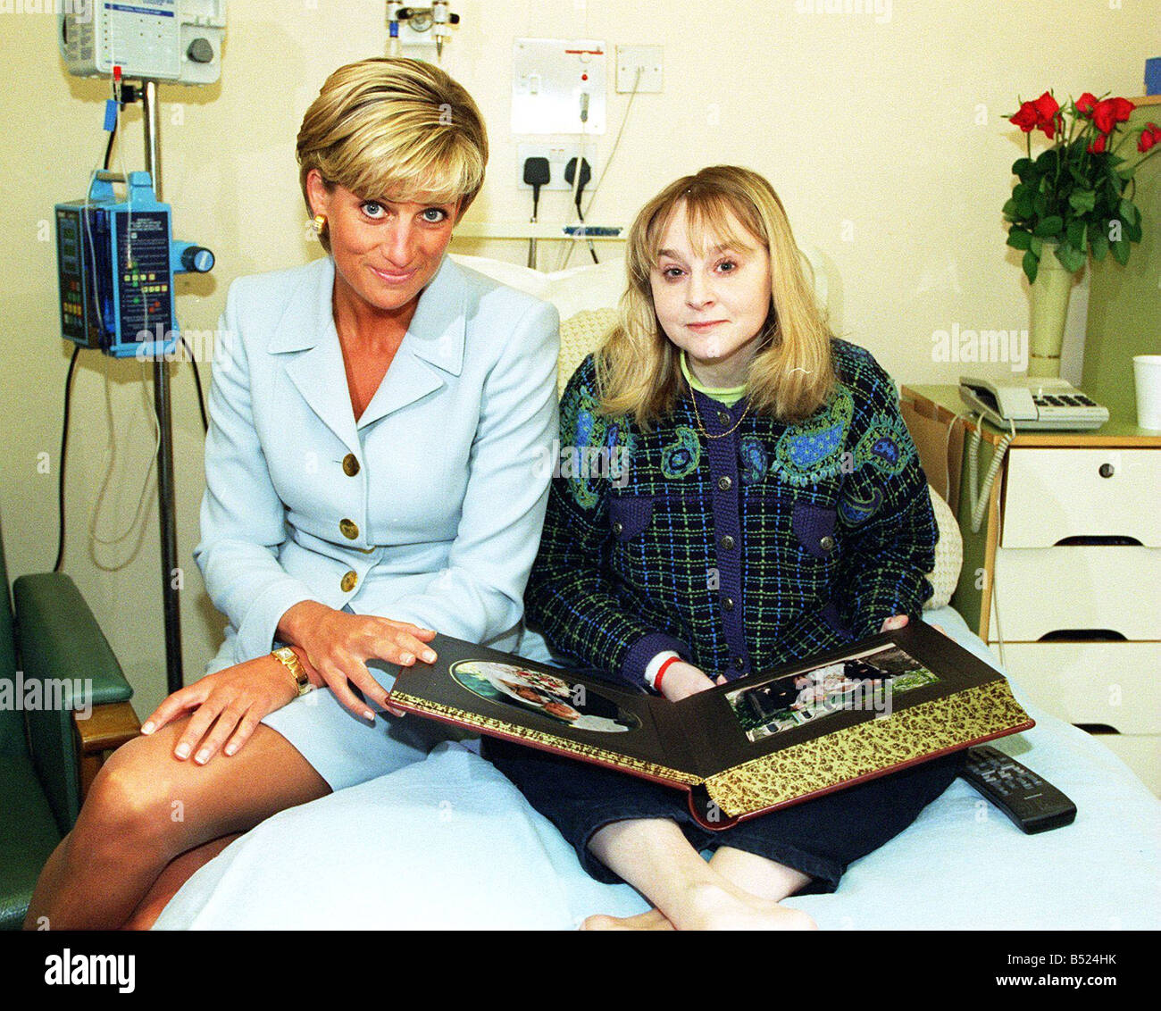 Prinzessin DIANA METS NICKY WELSH warten ON LUNG TRANSPLANT in BROMPTON Krankenhaus sitzen ON Bett auf der Suche in fotografieren ALBUM Diana trägt blass blau Versace Anzug Goldknöpfen Turn Back Manschetten Sonnenbräune Tan vanityfair0507 Stockfoto