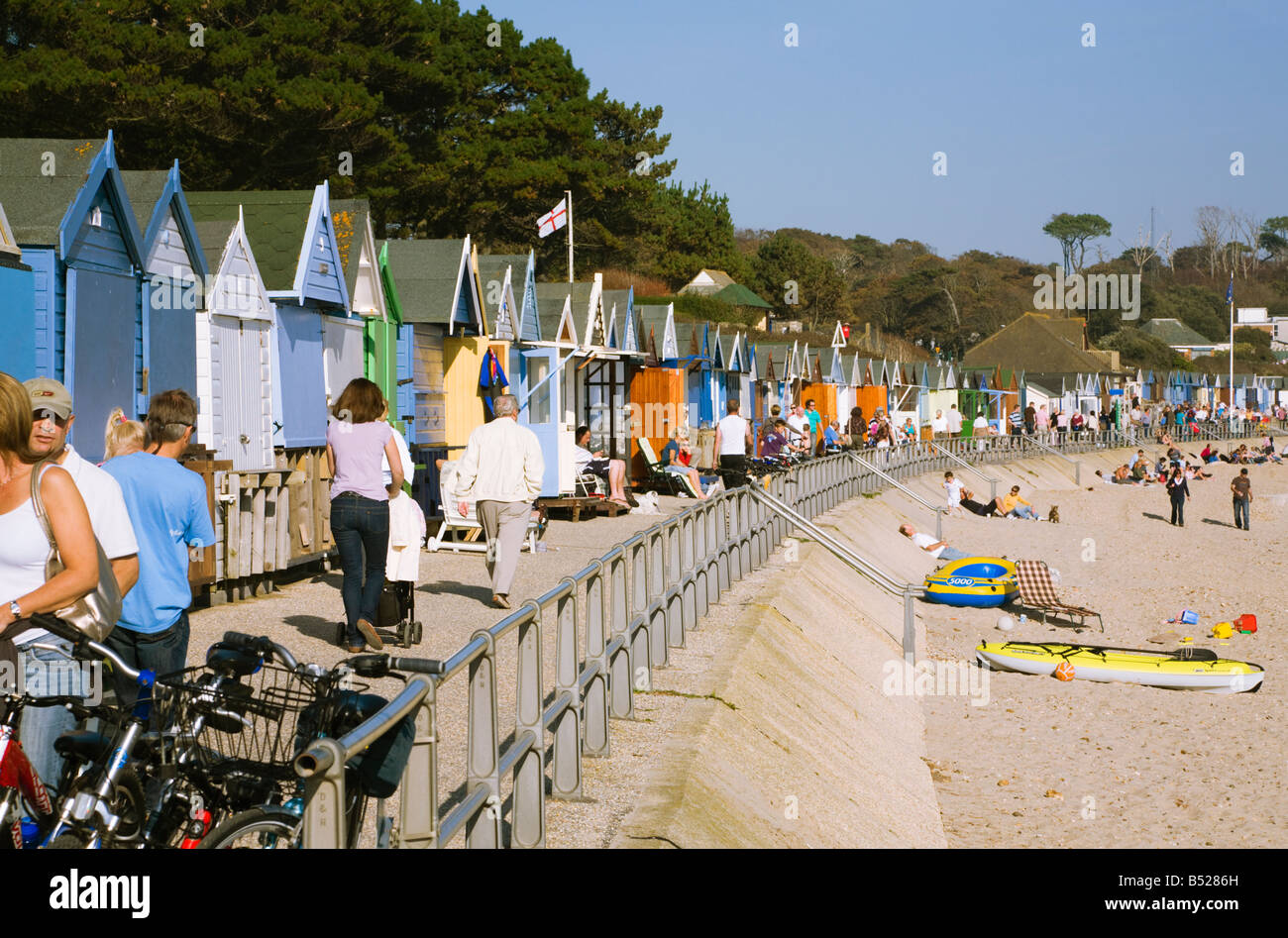 Ansicht von Menschen zu Fuß am Meer. Strand Hütten. Avon Strand, Christchurch, Dorset. VEREINIGTES KÖNIGREICH. Stockfoto